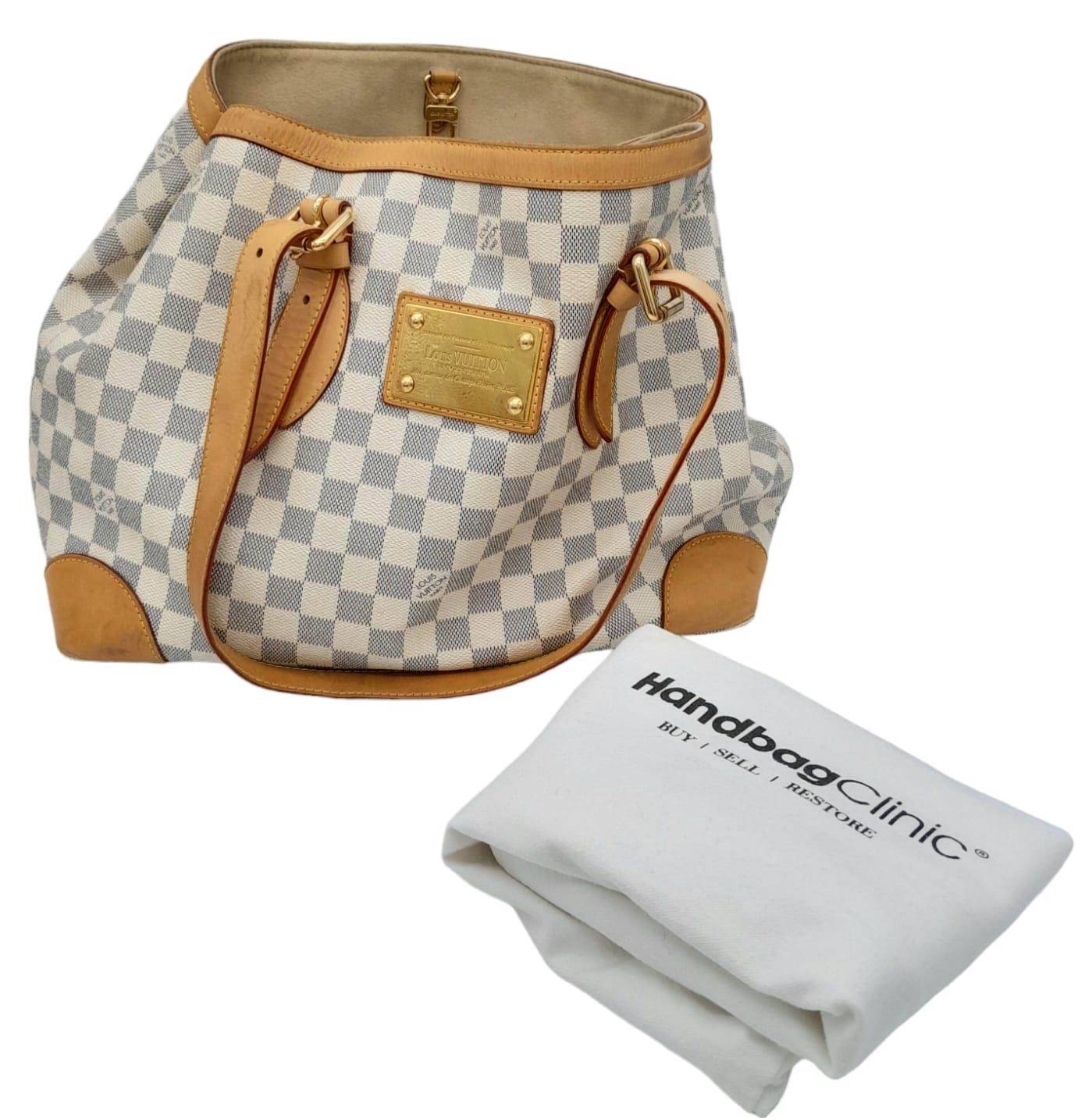 A Louis Vuitton Hampstead Bag. Damier azur leather exterior with gold-tone hardware, and snap hook