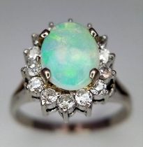 An 18K White Gold (tested) Opal and Diamond Ring. Central oval opal cabochon - 1ct approx,