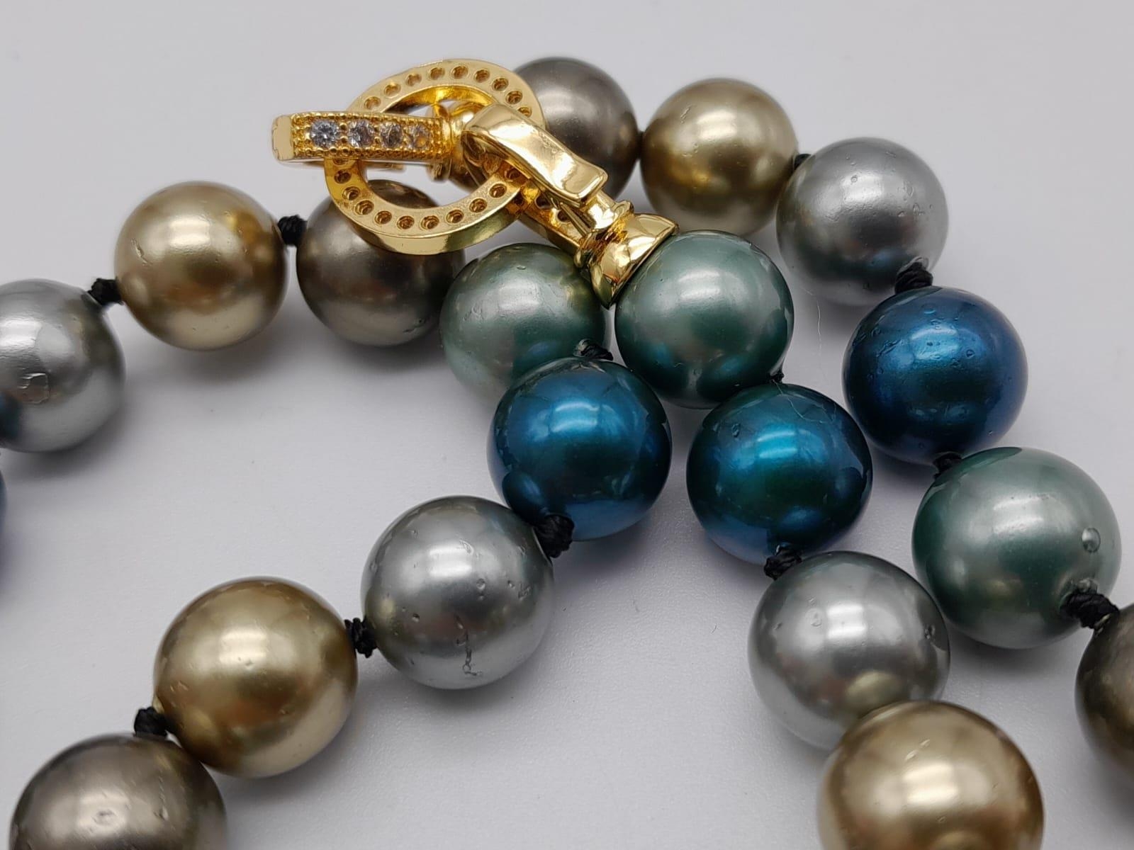 A Multi-Coloured South Sea Pearl Shell Bead Necklace. Gilded, silver and blue beads -12mm. 48cm. - Image 3 of 3