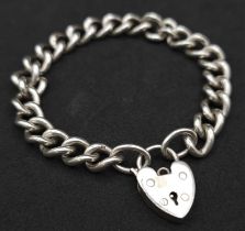 A Sterling silver chunky charm bracelet with heart padlock fastening. 31.6g