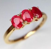 An Unworn 10 Carat Yellow Gold Ruby Set Trilogy Ring. Size P. Set with three 4mm Oval Cut Rubies.