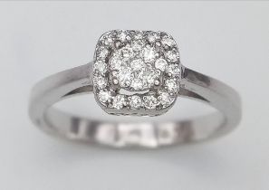 An 18K White Gold and Diamond Encrusted Ring. An encrusted circle within a square. Size J. 2.73g