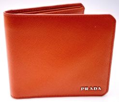A Prada Burnt Orange Wallet. Leather exterior and interior, with silver-toned logo hardware. Two