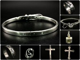 An eclectic collection of silver jewellery items. An adjustable bracelet, a locket chain bracelet (