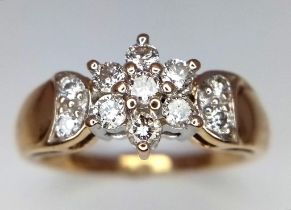 A 9K Yellow Gold Diamond Cluster Ring. Seven brilliant round cut diamonds in a floral shape with