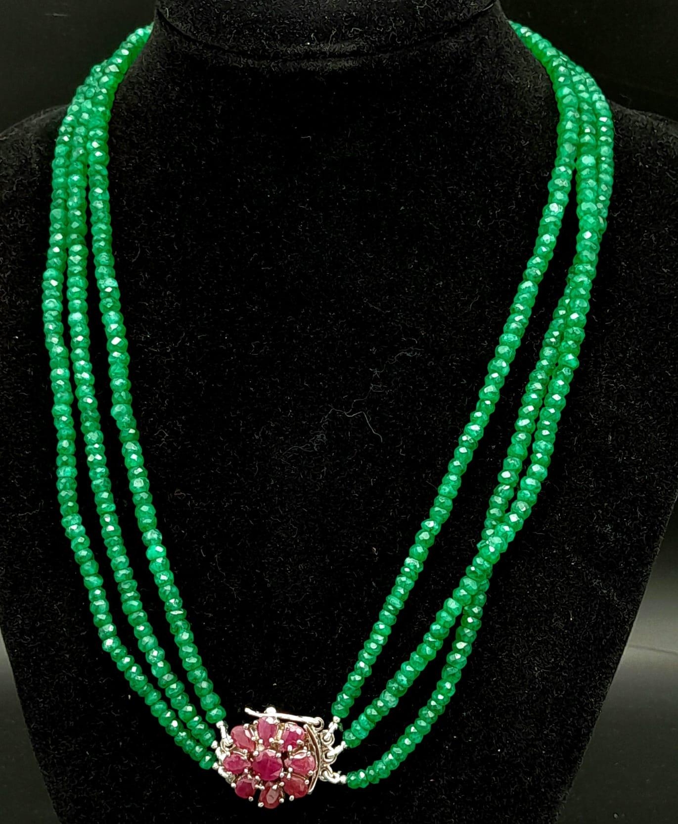 A Three Row Emerald Necklace with a Ruby and 925 Silver Clasp. 47.5cm in length, 250ctw emeralds,