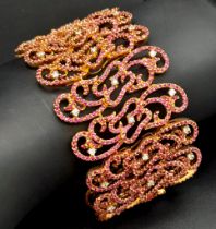 An 18K Rose Gold Ruby and Diamond Statement Bracelet. Interlocking ruby encrusted seahorse links