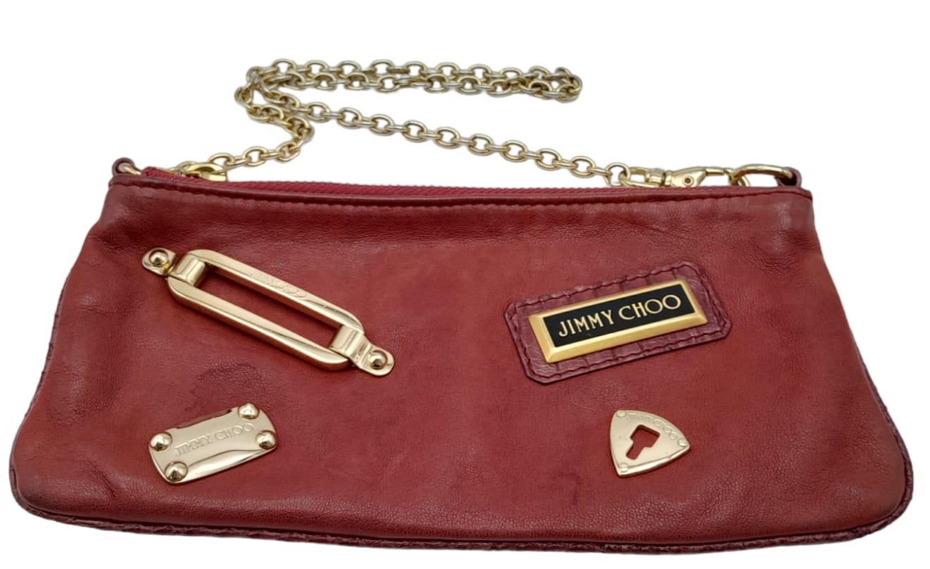 A Jimmy Choo Magenta Bag. Leather exterior with gold-tone hardware and chain strap. Canvas interior,