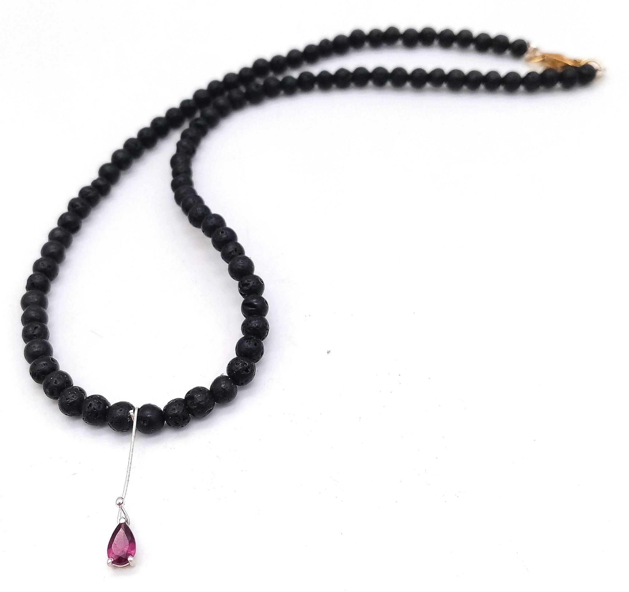 AN UNUSUAL 40cms BEADED NECKLACE MADE FROM VOLCANIC LAVA WITH A SMALL AMETHYST PENDANT . 12.2gms - Image 2 of 4