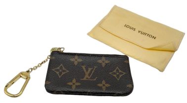 This Louis Vuitton Key Pouch in iconic Monogram canvas is a practical accessory that can carry