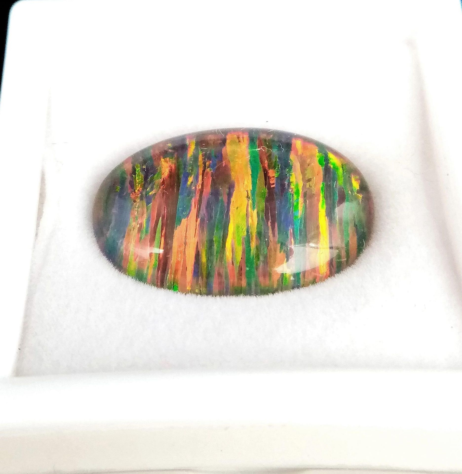 A truly magnificent, large (17.2 carats) GIBSON OPAL oval cabochon. Strong red and metallic green