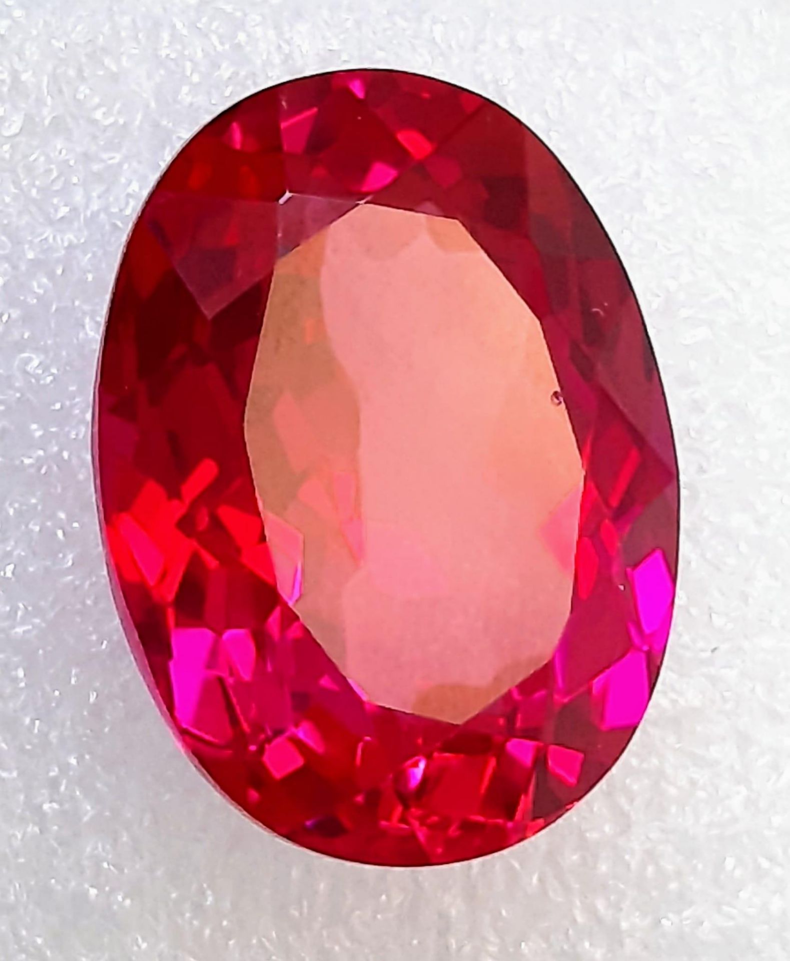 A top quality, large (51.7 carats), oval cut RUBY. Excellent colour saturation and uniformity,
