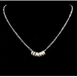 A Sterling Silver necklace with seven decorative rings. Measures 64cm in length. Weight: 6.4g