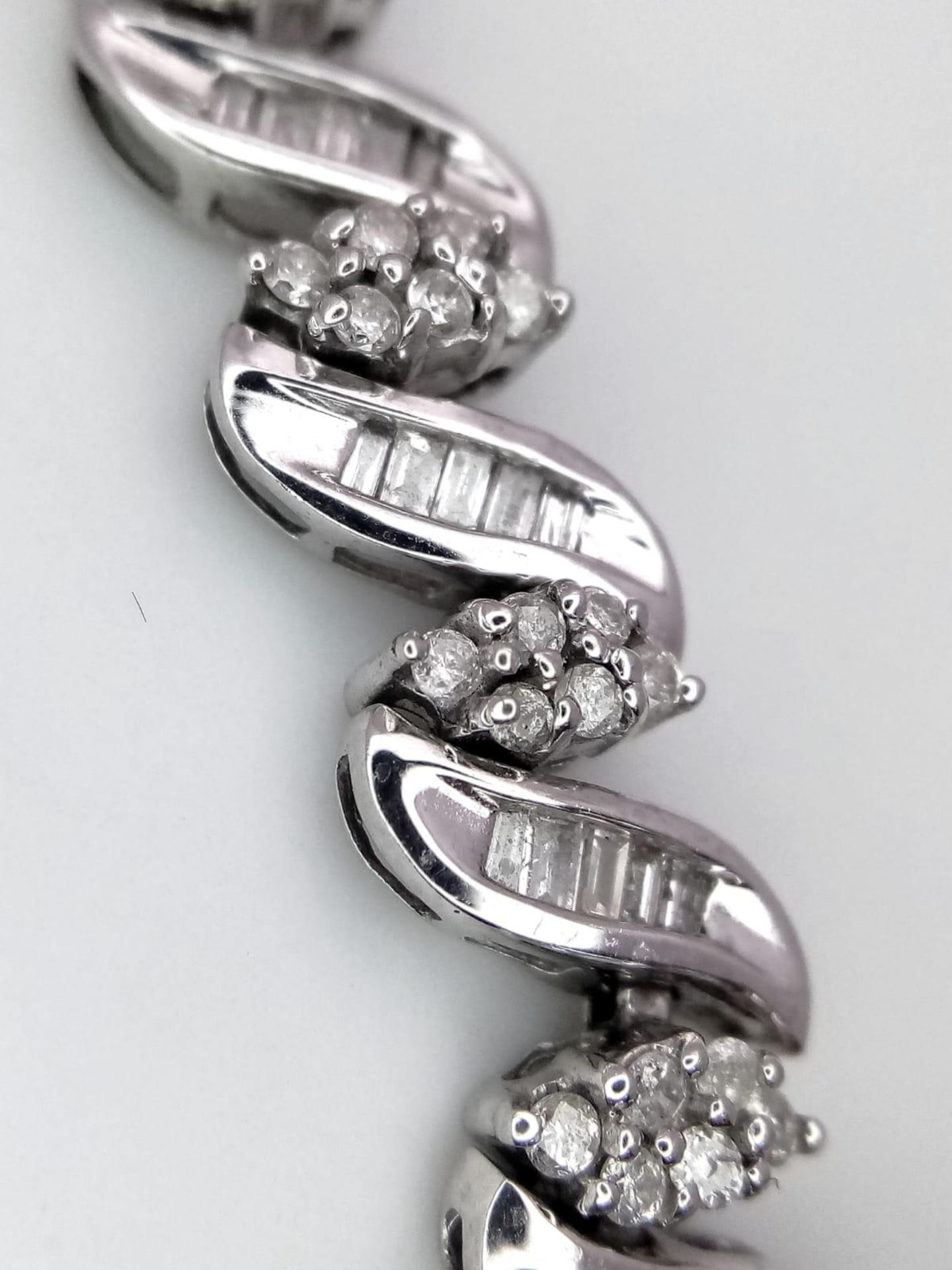 A 14K WHITE GOLD DIAMOND SWIRL BRACELET. A COMBINATION OF BAGUETTE AND ROUND CUT DIAMONDS 2.30CT - Image 3 of 7