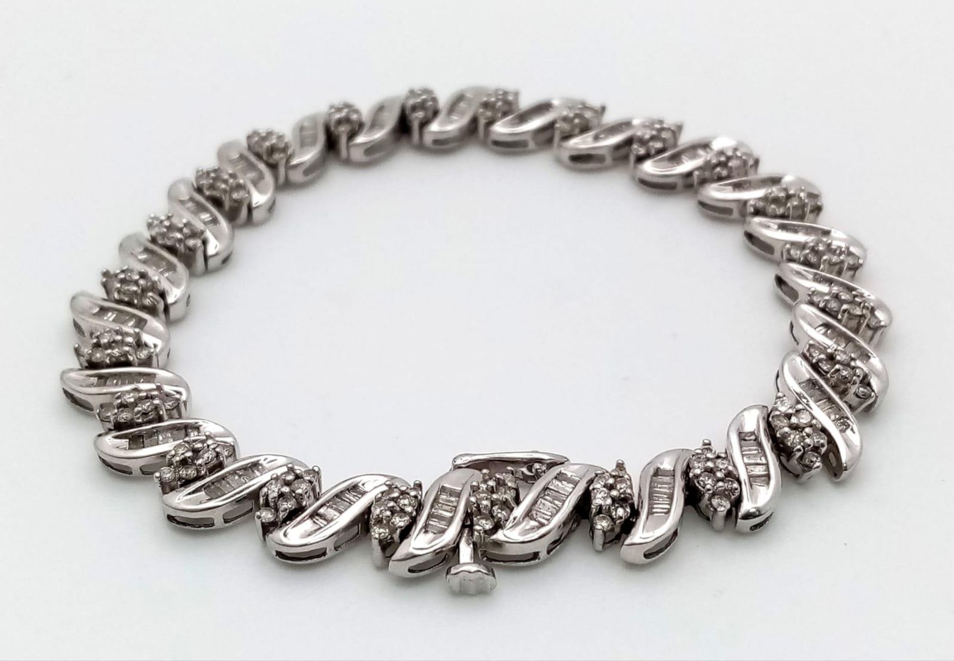 A 14K WHITE GOLD DIAMOND SWIRL BRACELET. A COMBINATION OF BAGUETTE AND ROUND CUT DIAMONDS 2.30CT - Image 5 of 7