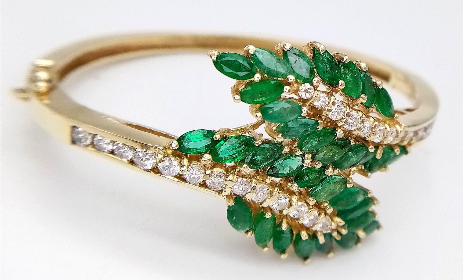 A DIAMOND AND EMERALD LEAF DESIGN BANGLE IN CROSSOVER STYLE SET IN18K GOLD . 33.5gms 10457 - Image 2 of 15