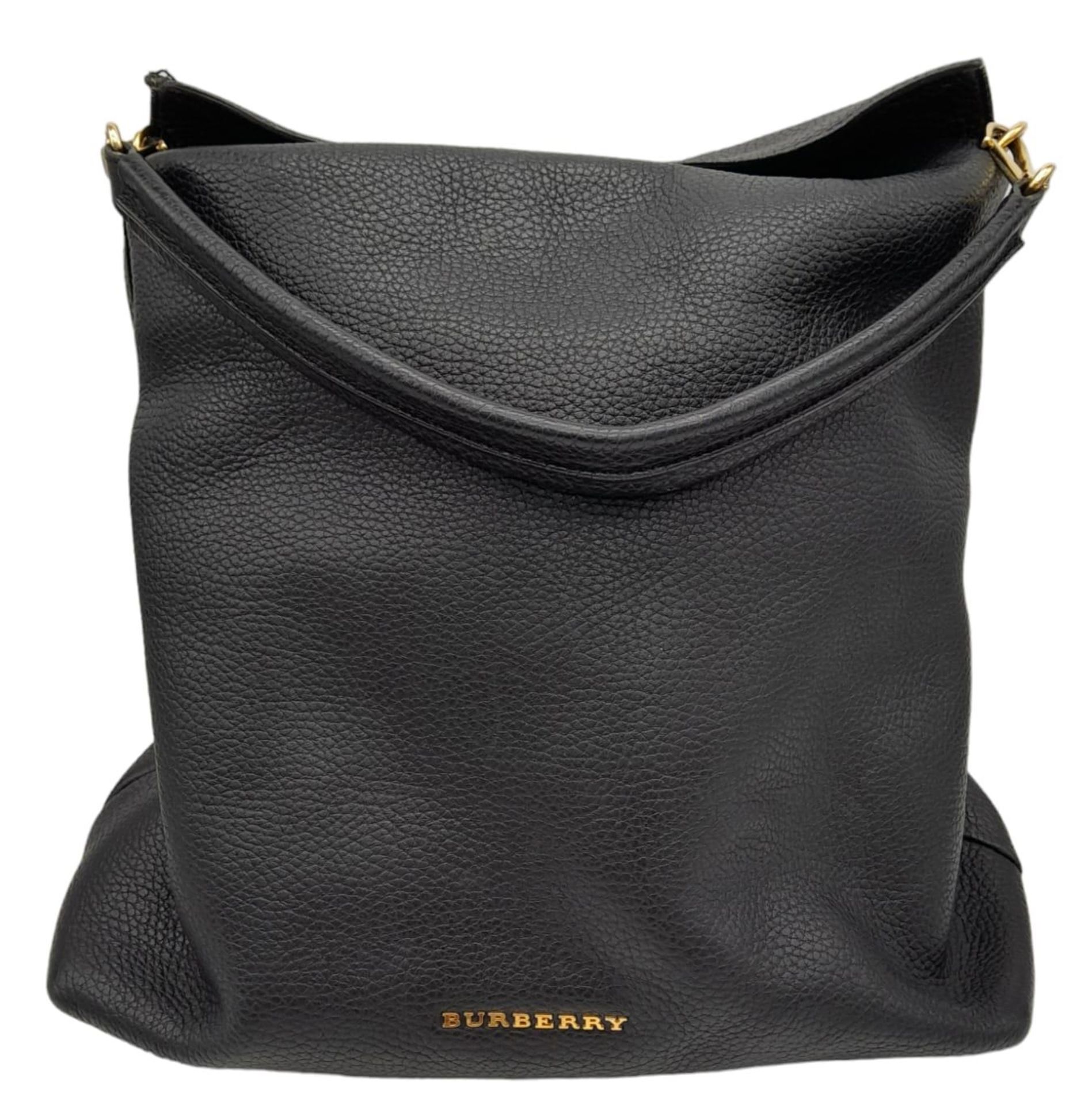 A Burberry Black Cale Hobo Bag. A leather exterior with a looping shoulder strap, gold tone hardware