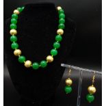 A high quality green jade and richly gilded necklace and earrings set, presented in a case. Necklace