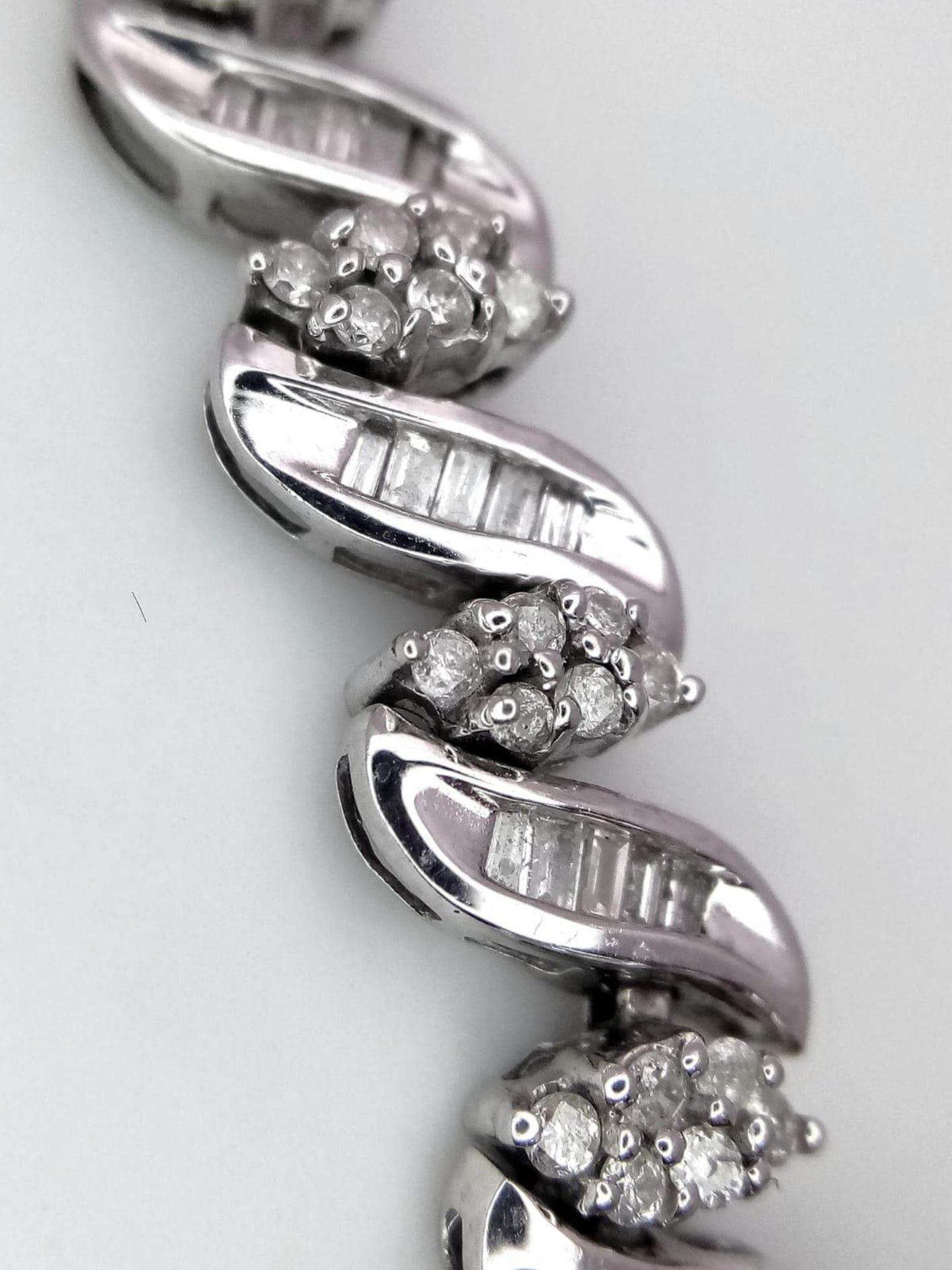 A 14K WHITE GOLD DIAMOND SWIRL BRACELET. A COMBINATION OF BAGUETTE AND ROUND CUT DIAMONDS 2.30CT - Image 2 of 7