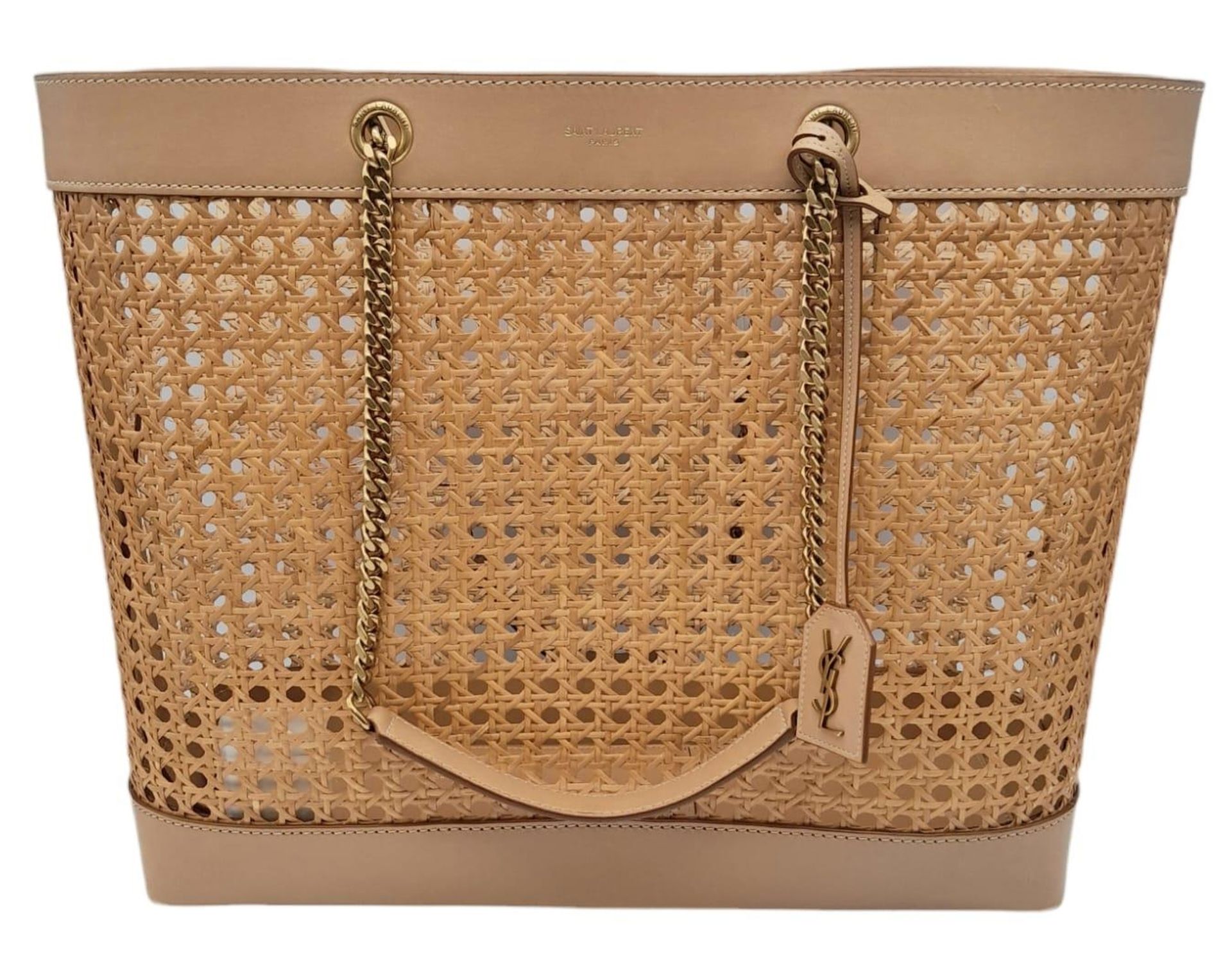 A Saint Laurent Beige Tote Bag. Woven rattan and leather trim exterior. Magnetic closure, gold-toned