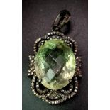 An Art Deco Style Green Amethyst and Diamond Pendant set in 925 Silver. Oval faceted-cut. Green