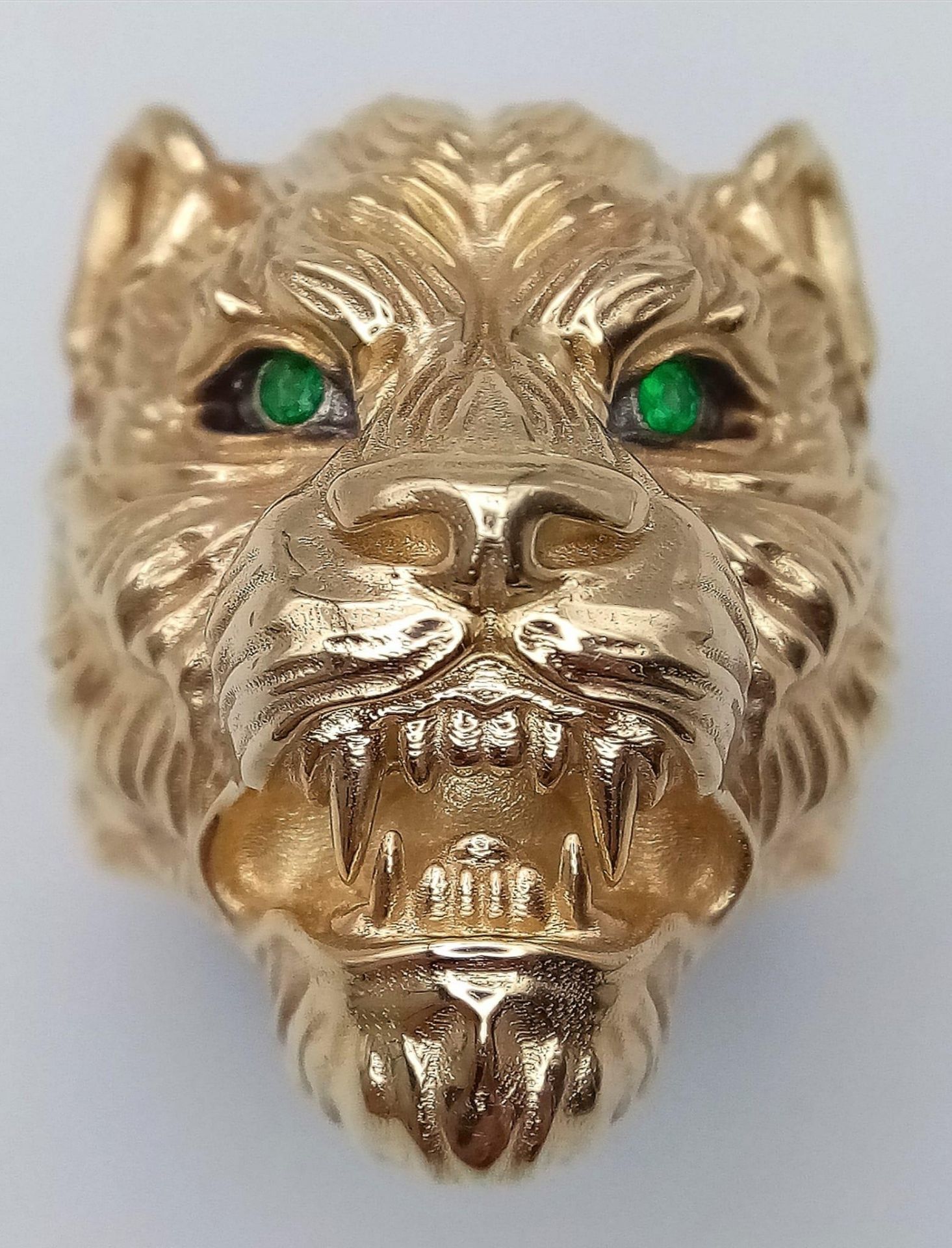 A 9K YELLOW GOLD TIGER / LEOPARD HEAD RING WITH GREEN STONES SET IN THE EYES. 10.8G. SIZE S