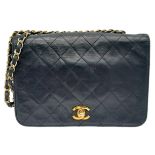 Black Chanel Handbag. Quilted leather stitched in diamond pattern. Gold & Silver toned hardware with