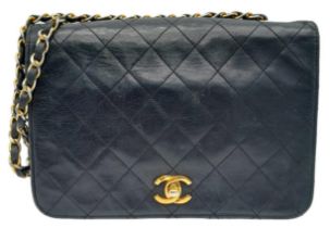 Black Chanel Handbag. Quilted leather stitched in diamond pattern. Gold & Silver toned hardware with