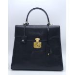 Black Gucci Top Handle Bag. Exotic, shiny lizard leather featuring gold toned hardware, flip-lock