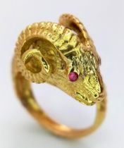 AN 18K YELLOW GOLD RAMS HEAD RING - WITH STONE SET EYES. 11.4G. SIZE O.
