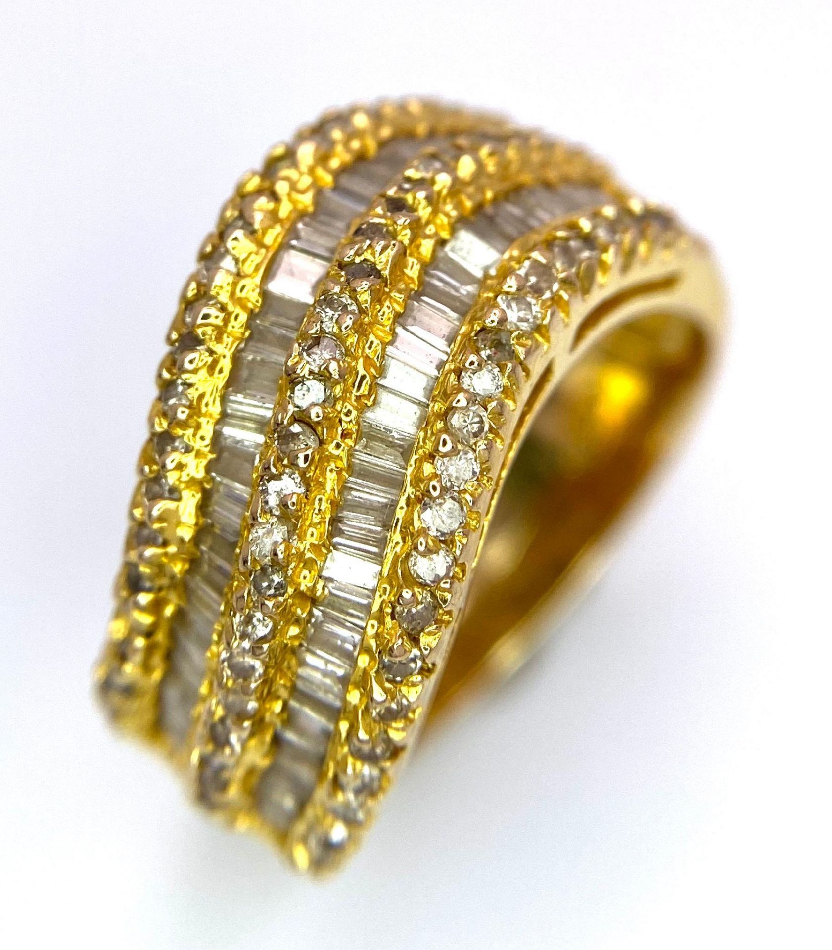 AN 18K YELLOW GOLD DIAMOND SET 5 ROW BAND RING. 1.10CTW OF ROUND BRILLIANT AND TAPERED BAGUETTE