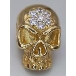 A 14K YELLOW GOLD HIRST-ESQUE STONE SKULL PENDANT. 4.4G