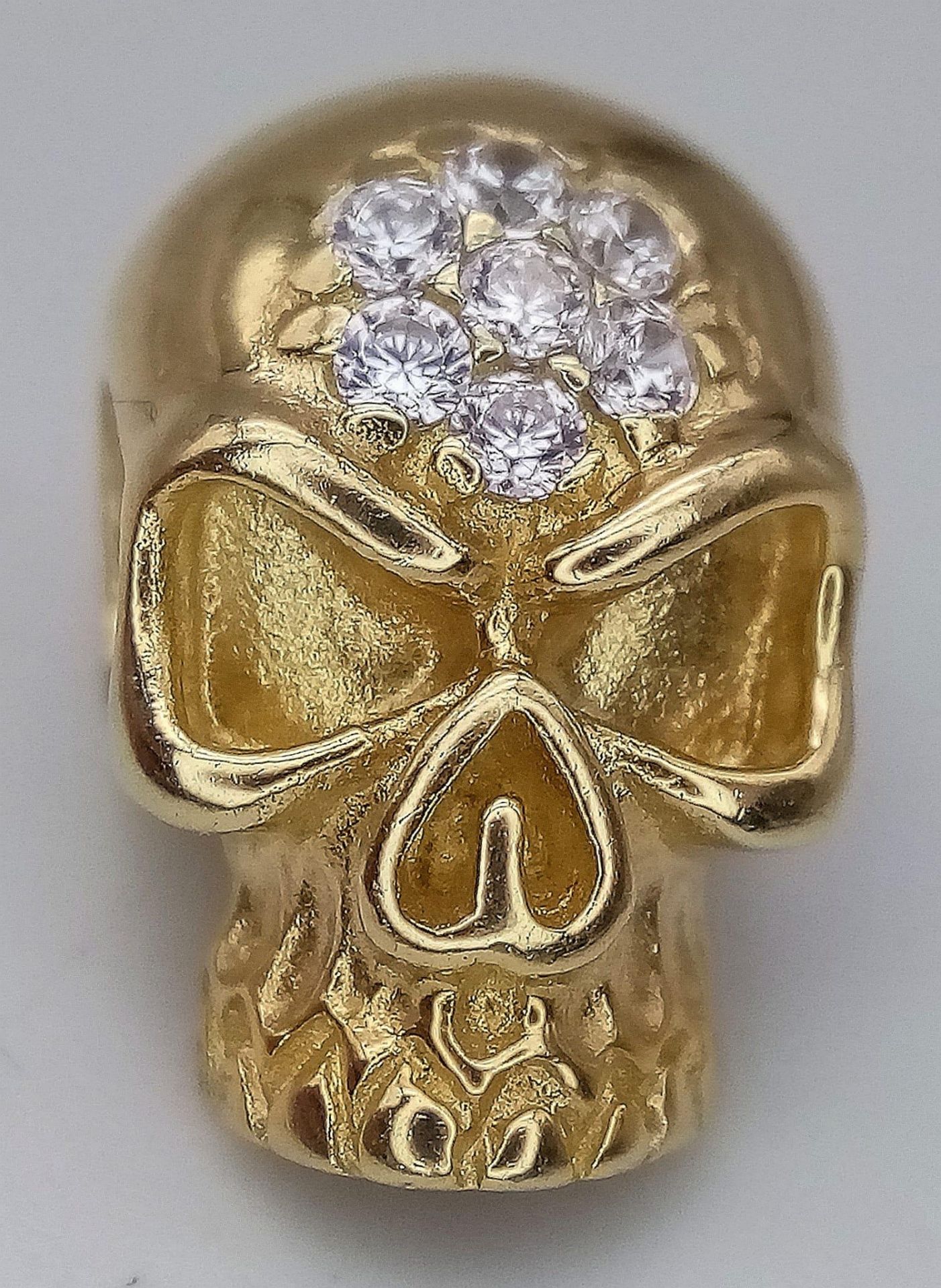 A 14K YELLOW GOLD HIRST-ESQUE STONE SKULL PENDANT. 4.4G