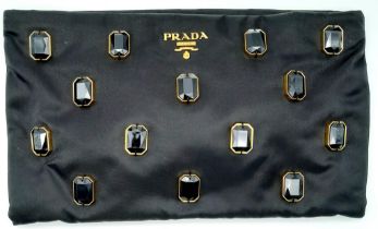 A Prada Black Jewel Clutch. Textile exterior embellished with black stones. Gold toned hardware