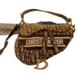 Christian Dior Saddle Handbag. Brown monogrammed velvet bag with gold tone hardware. Additional,