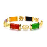 A Multi-Coloured Jade Bar Bracelet. A rainbow of colours between god plated Chinese calligraphy.