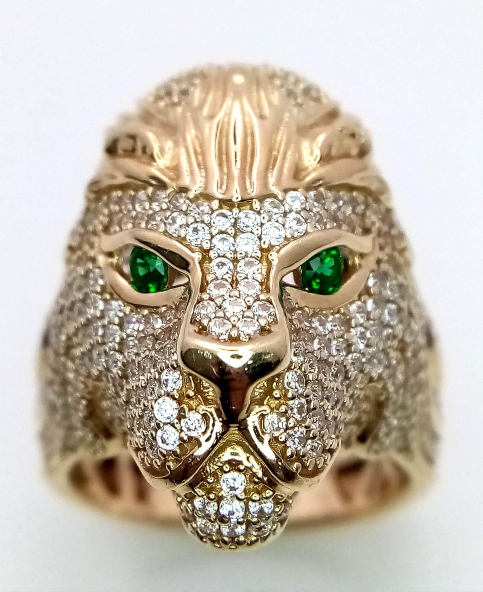 A 9K YELLOW GOLD STONE SET LIONS HEAD RING. 11.5G. SIZE T