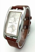 A LADIES DUAL TIME ZONE WATCH BY HERMES OF PARIS IN STAINLESS STEEL AND ON THE ORIGINAL HERMES