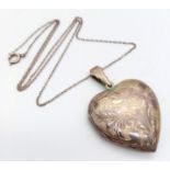 A vintage sterling silver 5cm heart locket pendant on silver chain. Total weight 12.35G. Total