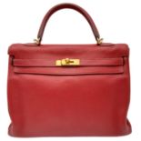 A Hermes Red Kelly Bag. Veau togo leather exterior, with gold toned hardware, single handle, four