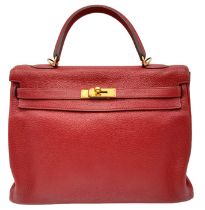 A Hermes Red Kelly Bag. Veau togo leather exterior, with gold toned hardware, single handle, four