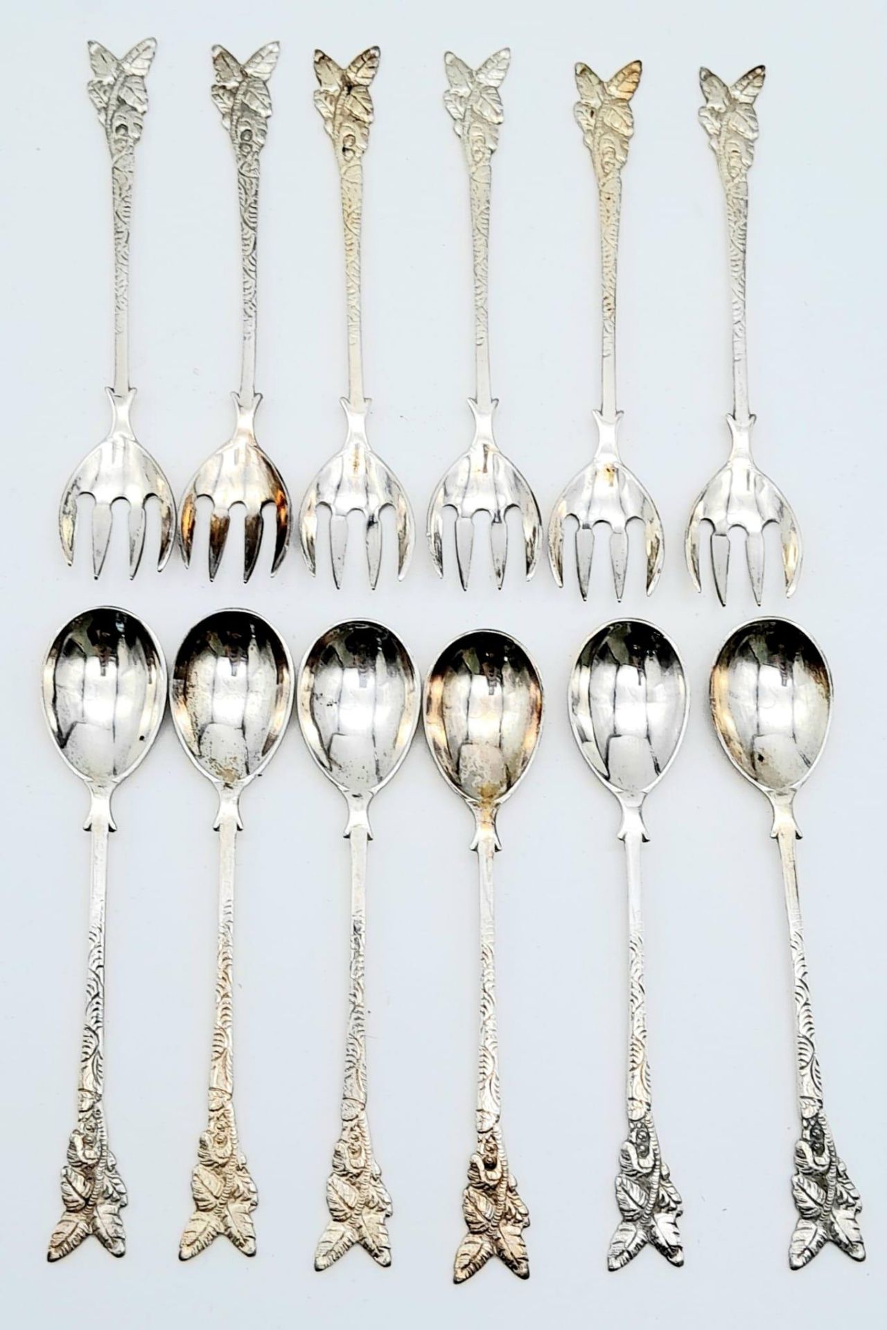 Parcel of antique silver cutlery. Featuring six ornately handled spoons and six forks. Stamped
