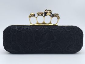 Alexander McQueen Skull & Gem Ring Clutch. Black floral embroidered exterior with gold tone