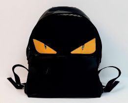 A Fendi Monster Black Backpack. Canvas and leather exterior, with two large yellow monster eyes, a