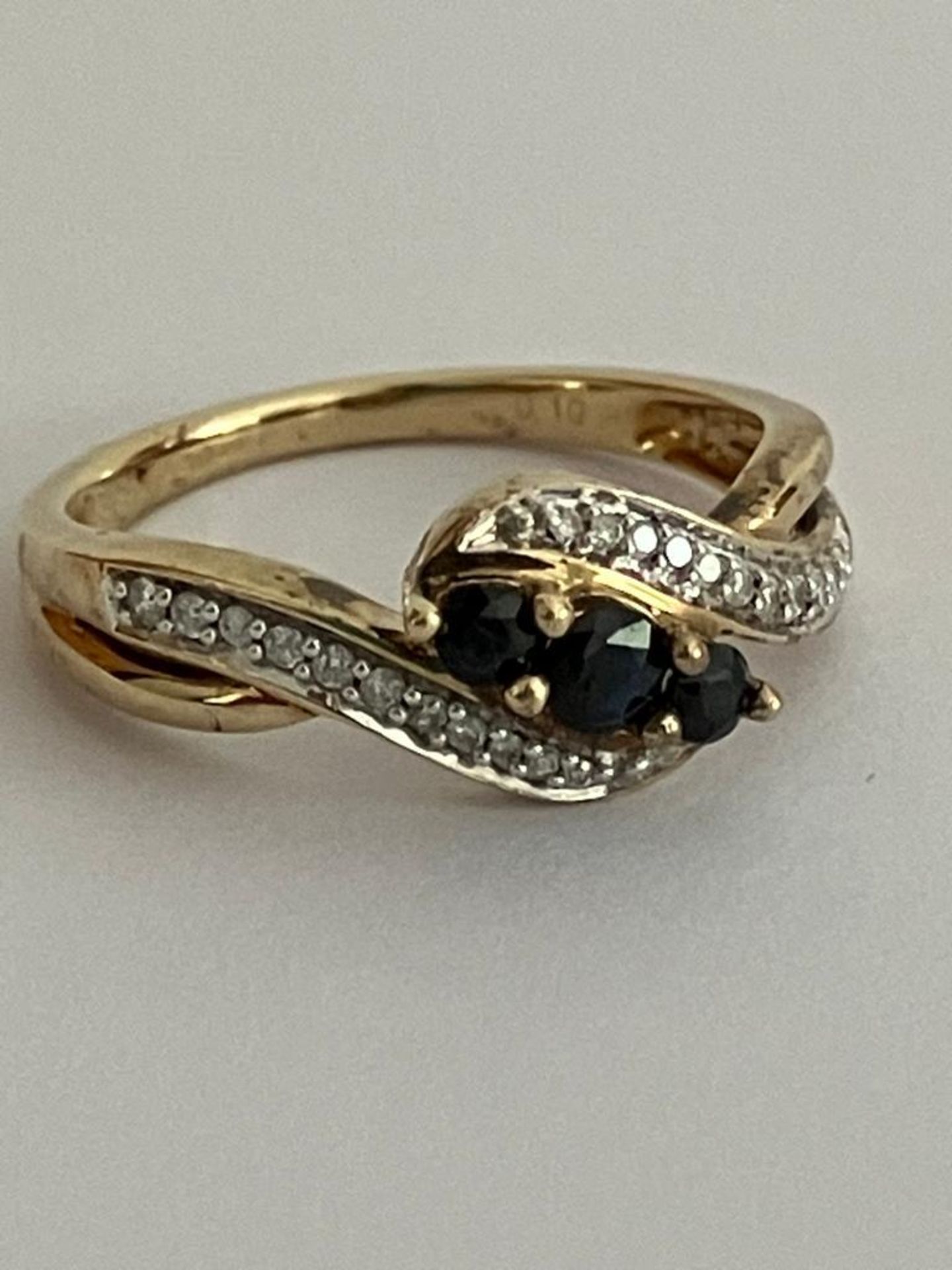 9 carat GOLD, DIAMOND and SAPPHIRE RING, Crossover design with attractive split shoulder detail.