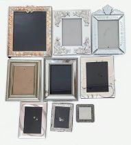 A collection of 9 frames. In various shapes, sizes and design. Some glass, some wood and some metal.