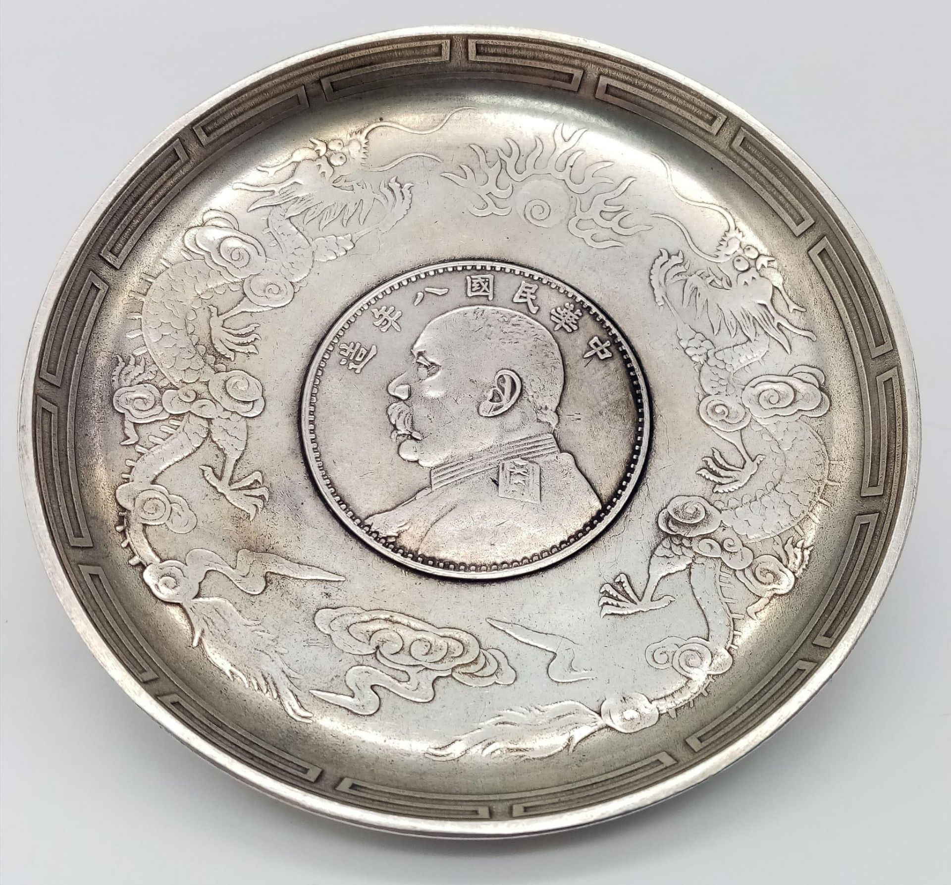 An Antique Chinese Silver, Yuan Coin Set, Dragon & Bat Detail Dish. Circa 1914, it measures 9.3cm