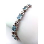 A Blue Topaz Tennis Bracelet. Rectangular cuts of ice blue topaz set in 925 silver. 19cm. 17.2g