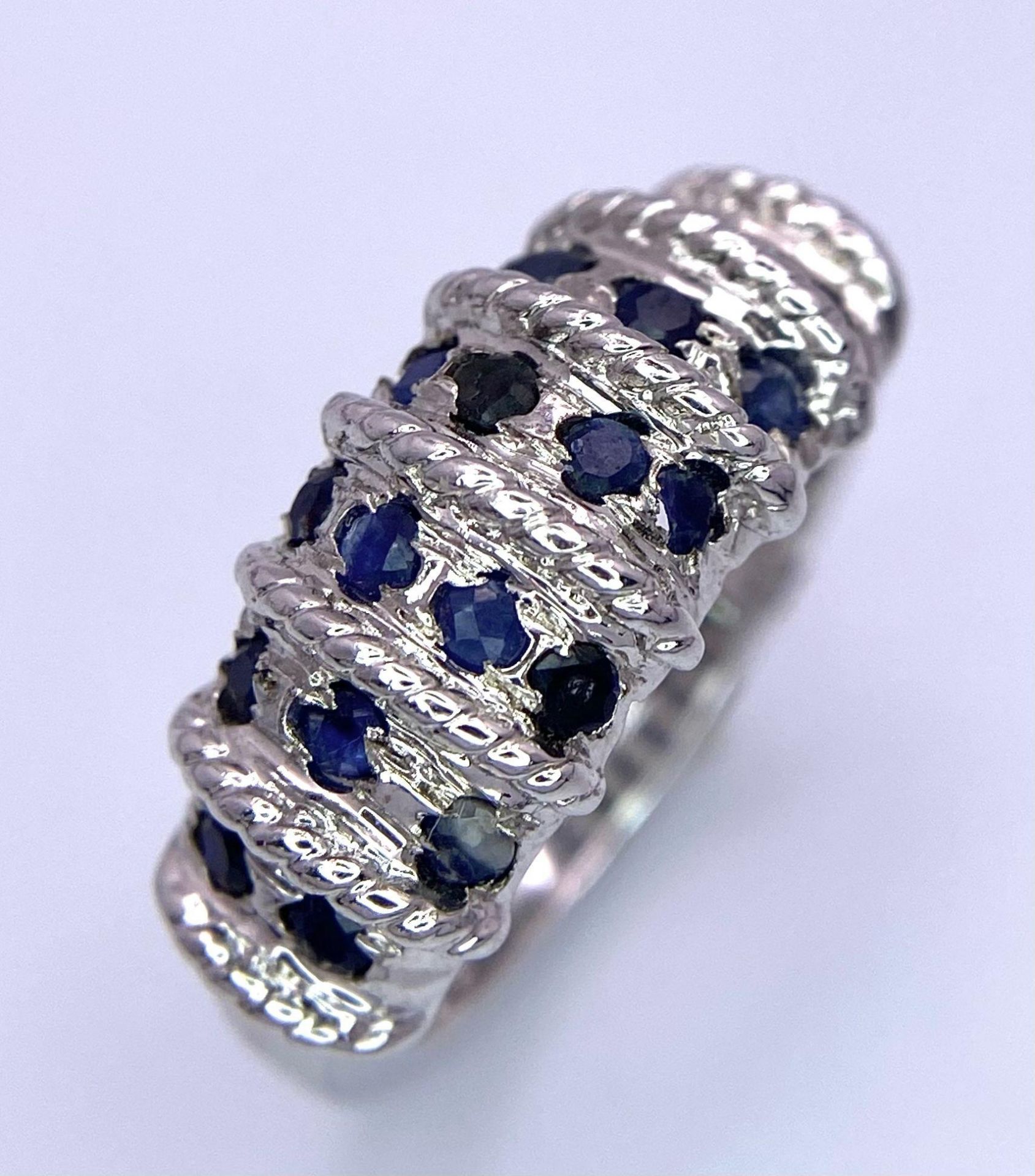 A Graduating Vertical Band Sapphire 925 Silver Ring. Sapphires - 2ctw. 4.77g total weight. Size M.