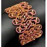 An 18K Rose Gold Ruby and Diamond Statement Bracelet. Interlocking ruby encrusted seahorse links